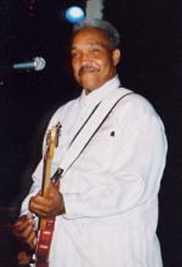 Johnny Rawls performing on stage in white jacket